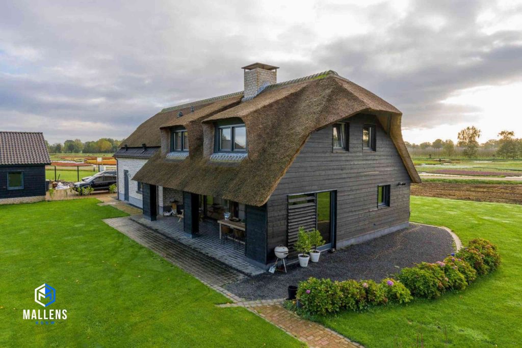 De woning van schuin voren bekeken. De woning heeft een overkapping met daaronder een eettafel.