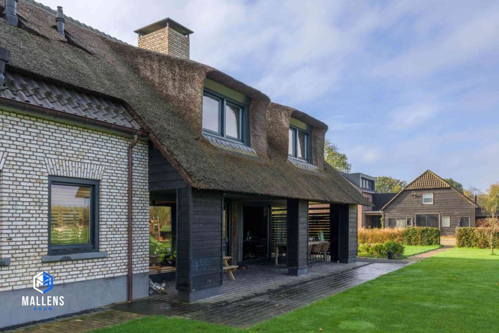 De overkapping die vanuit het dak doorloopt. Bovenop het dak staan twee grote dakkapelen.