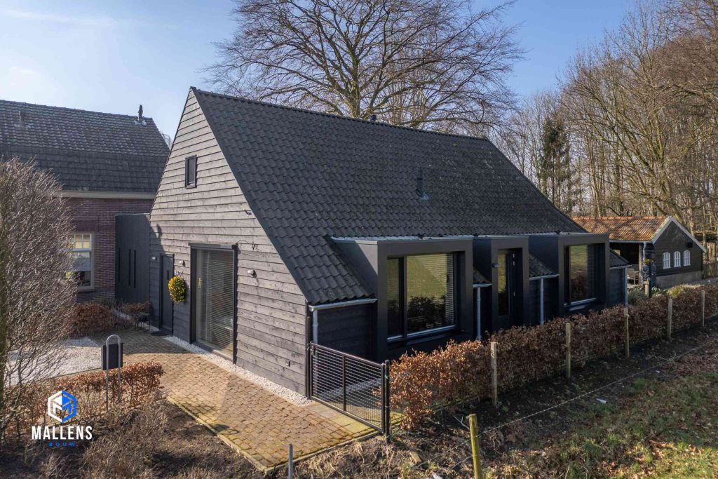 Het zijaanzicht van het gebouw met 3 grote en uitgebouwde ramen.