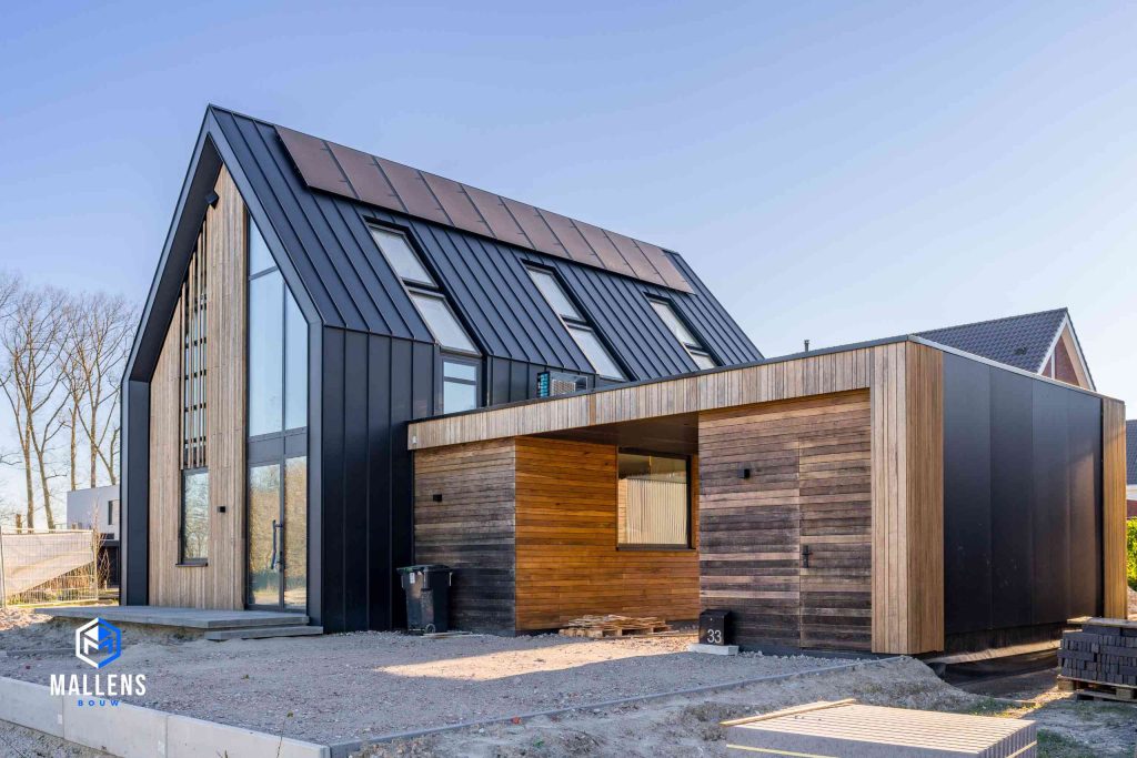 Zijaanzicht van de woning in Udenhout, met goed zicht op de houten uitbouw.