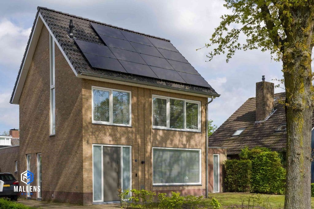 De gerenoveerde woning in Udenhout van de schuin van voren bekeken Op het dak liggen zonnepanelen.