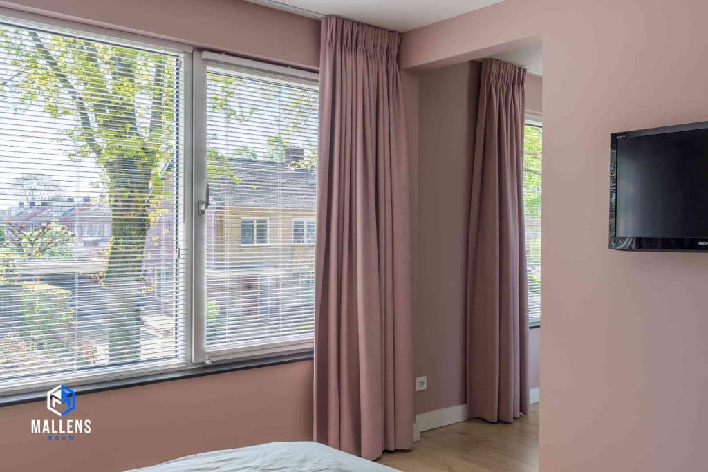 De slaapkamer ramen met roze gordijnen.
