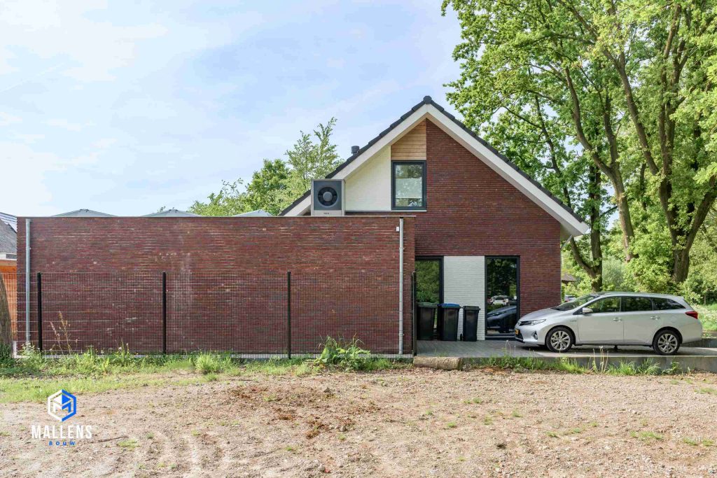 De zijkant van de woning, waar je uitkijkt op de garage.