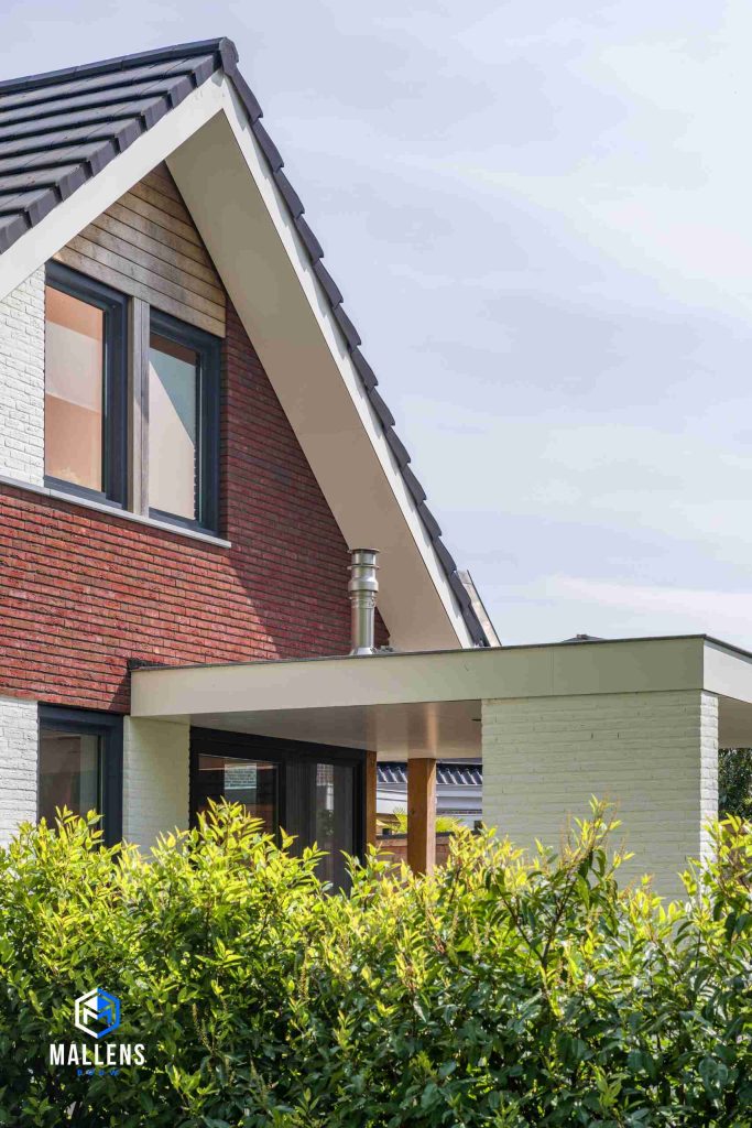 Je ziet een stukje van de veranda en het puntdak van de woning.