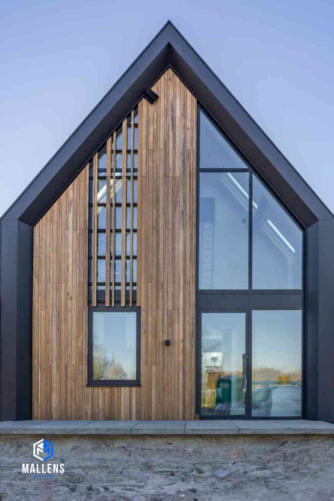 Een nieuwbouw woning van voren bekeken. Het is een combinatie van hout en aluminium frame met veel ramen.